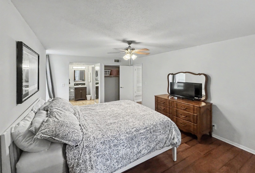 Bedroom featuring wood-finish flooring, a ceiling fan with integrated lighting, and a neutral color palette
