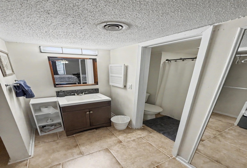 Bathroom featuring a sink vanity with a dark wood-finish cabinet and integrated white basin