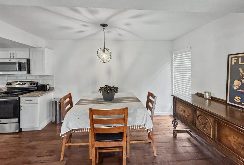 Dining area featuring rich wood-finish flooring and a contemporary pendant light fixture