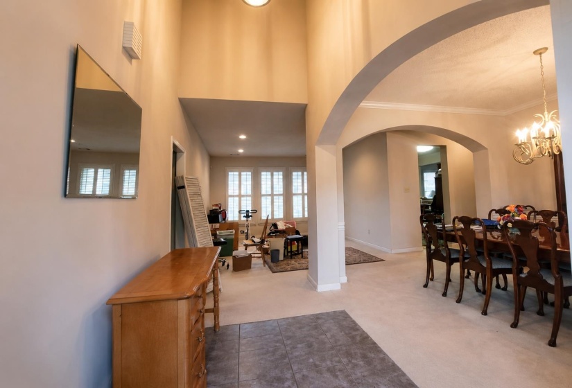 Two-story foyer with tile flooring and recessed lighting
