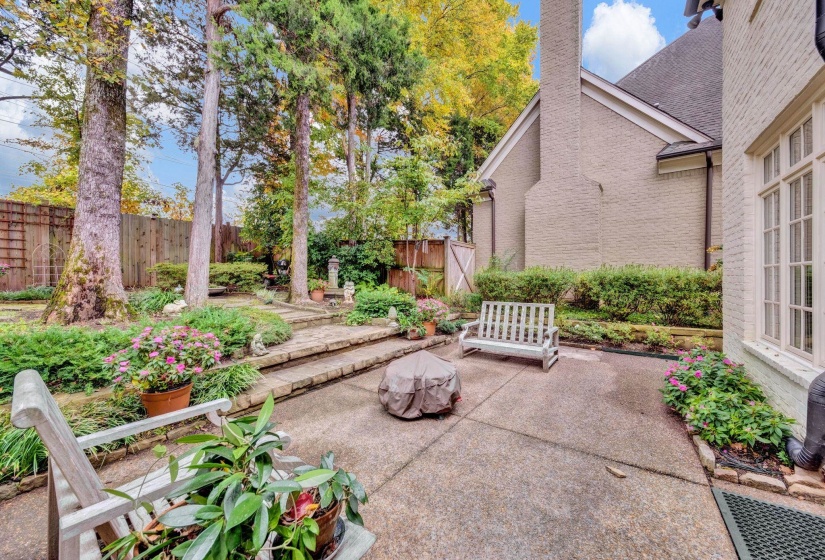 Tranquil private courtyard overlooking beautifully landscaped, terraced gardens and mature trees, offering ample patio space for entertaining, dining al fresco, or peaceful relaxation.