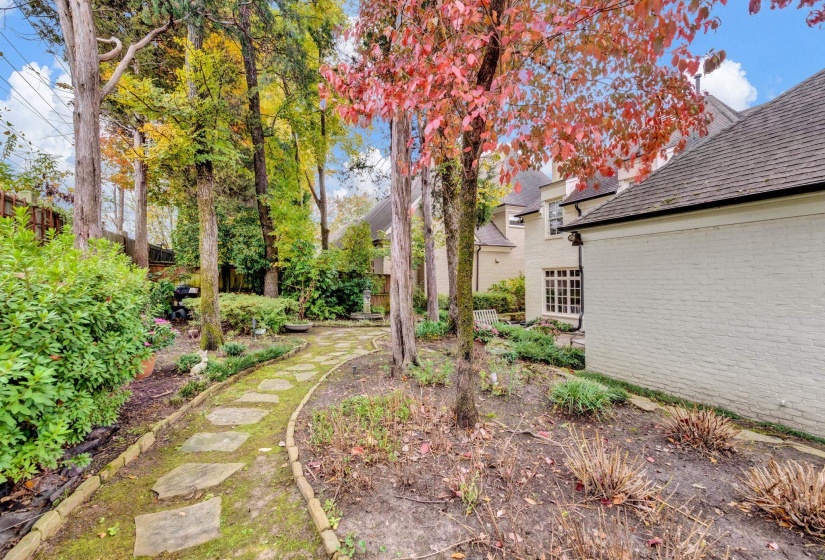 Picturesque backyard path winding through mature trees and lush landscaping, creating a serene outdoor escape.