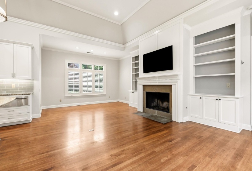 Light-filled breakfast nook in the kitchen with picturesque front garden views and an inviting fireplace, creating the perfect setting for casual dining and morning coffee. Built-in shelving adds charm and convenience.