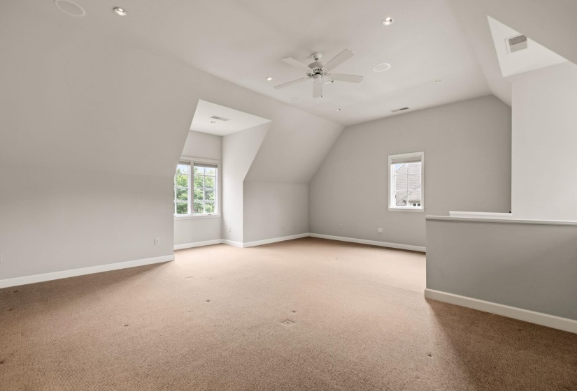Secluded media room located up a private rear stairwell behind the kitchen—ideal for a home theater, game room, or quiet retreat.