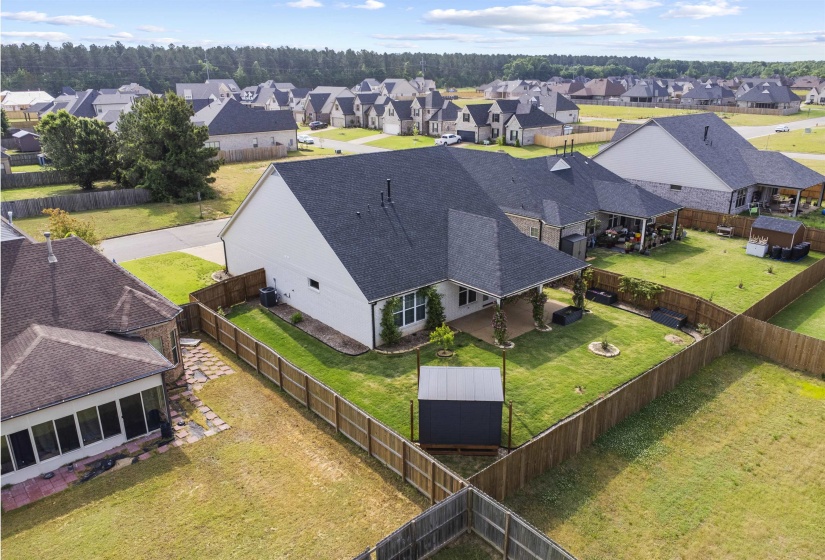 Expansive backyard featuring a manicured lawn, a covered patio, and a privacy fence