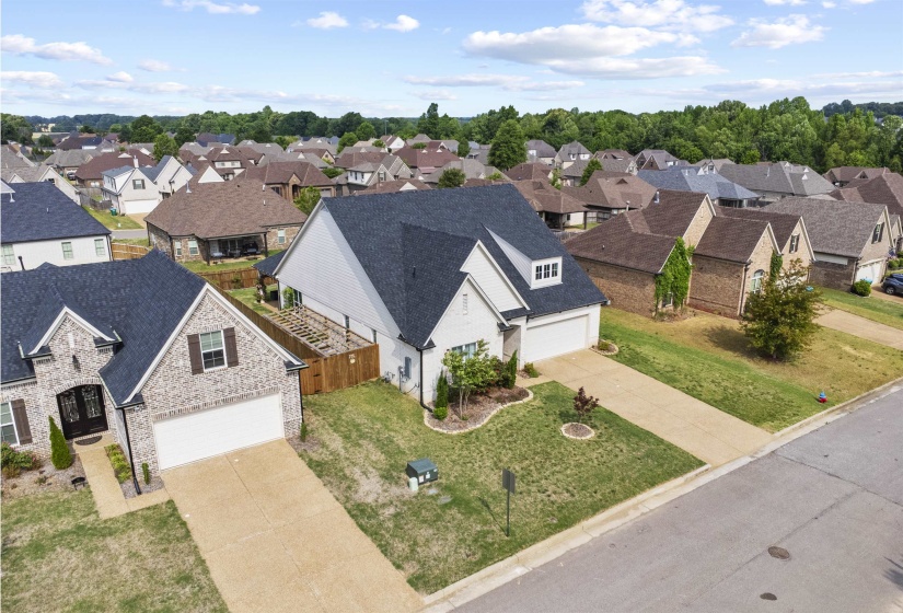 Residential street with established homes featuring varying exterior materials and attached garages