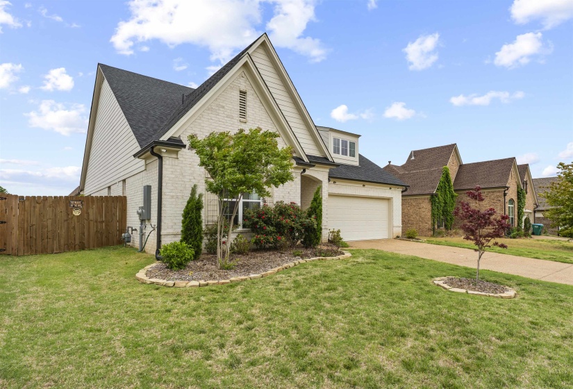 White brick exterior with dark shingle roofing