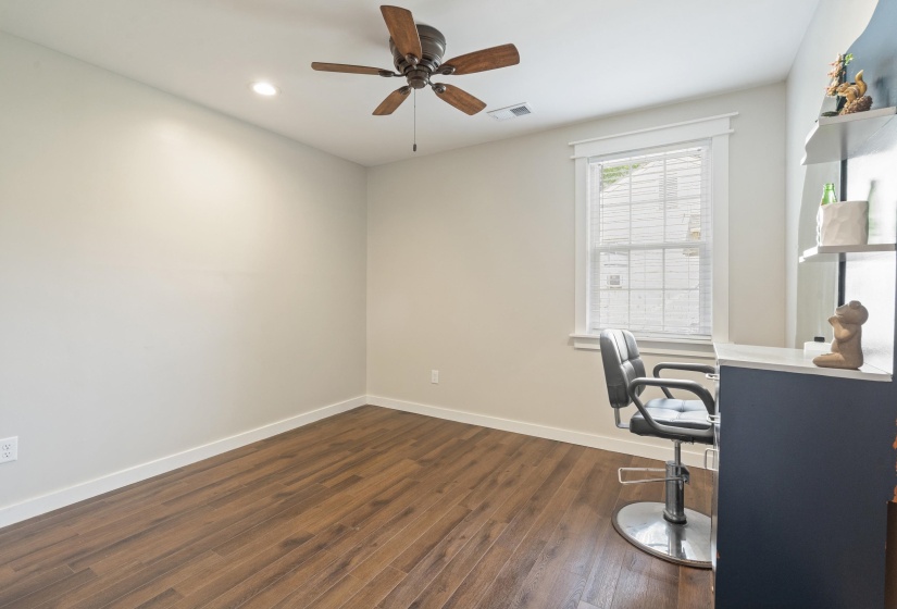 Room featuring wood-finish flooring, light neutral walls, and a white-trimmed window