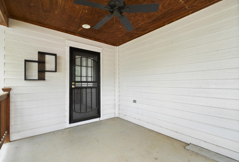 Covered exterior patio featuring white horizontal siding and a wood-finish ceiling