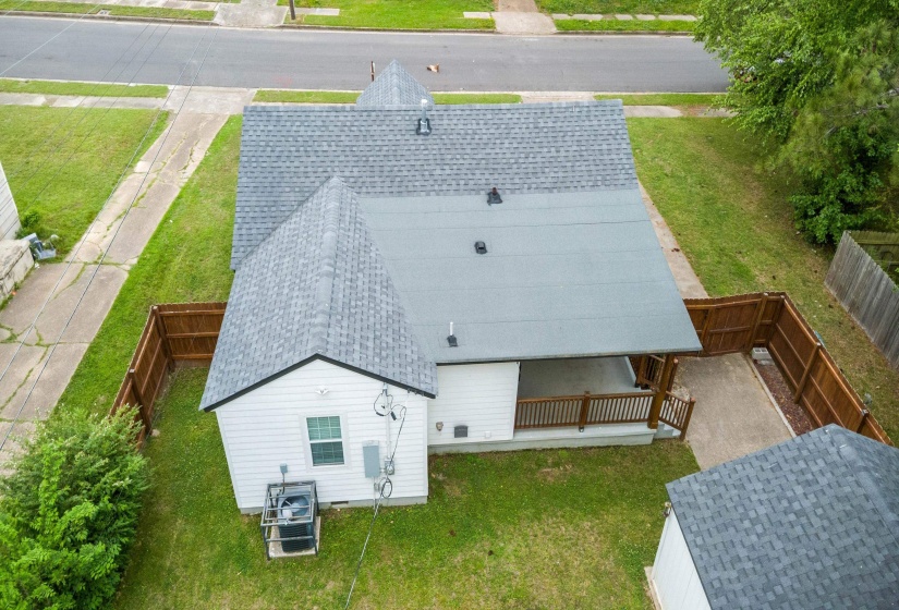 Residential property featuring a grey shingle roof, white siding, and a fenced backyard