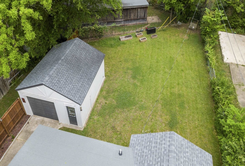 Detached garage with a dark gray overhead door and side entry, set on a concrete pad