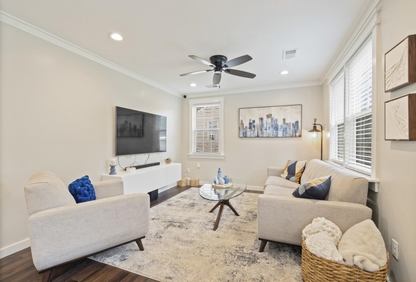 Living area featuring crown molding, recessed lighting, and wood-finish flooring