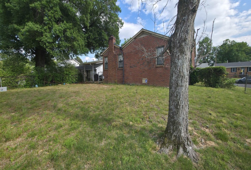 Expansive grassy yard with mature trees