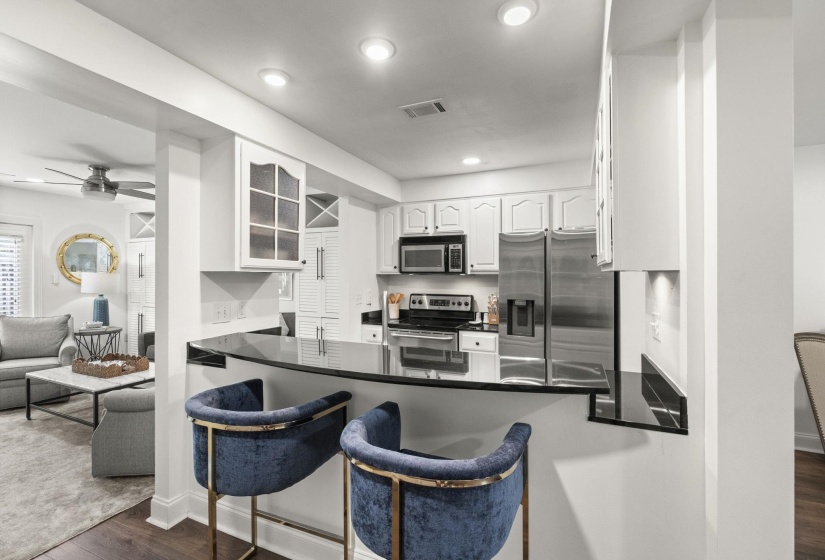 Kitchen featuring black countertops, white cabinetry, and stainless steel appliances