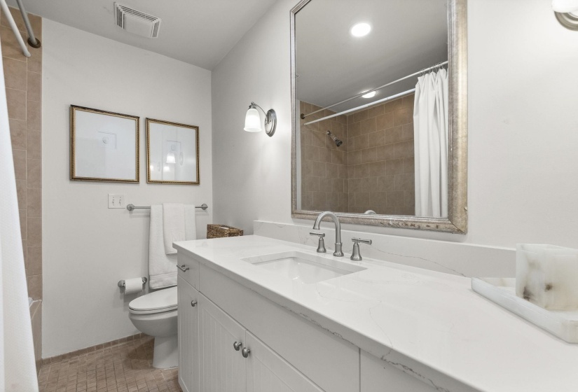 Bathroom featuring a white vanity with a light-toned countertop, a rectangular undermount sink, and brushed nickel fixtures