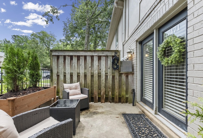 Private patio space featuring concrete surfacing and a wood privacy fence