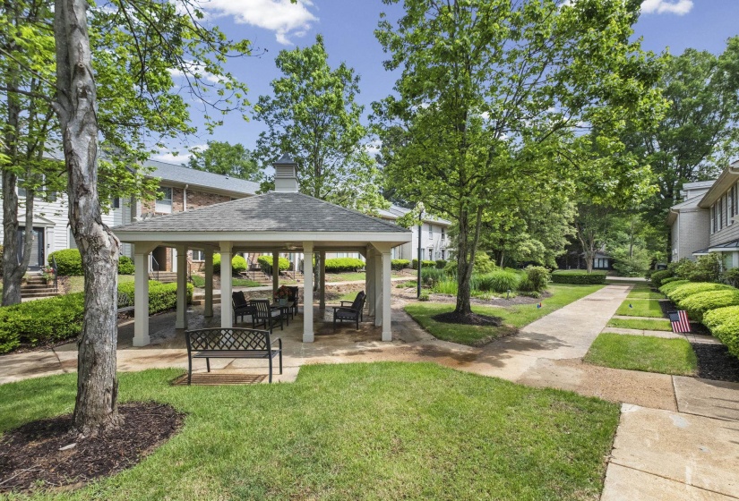 Central gazebo with seating, surrounded by manicured lawns and mature trees
