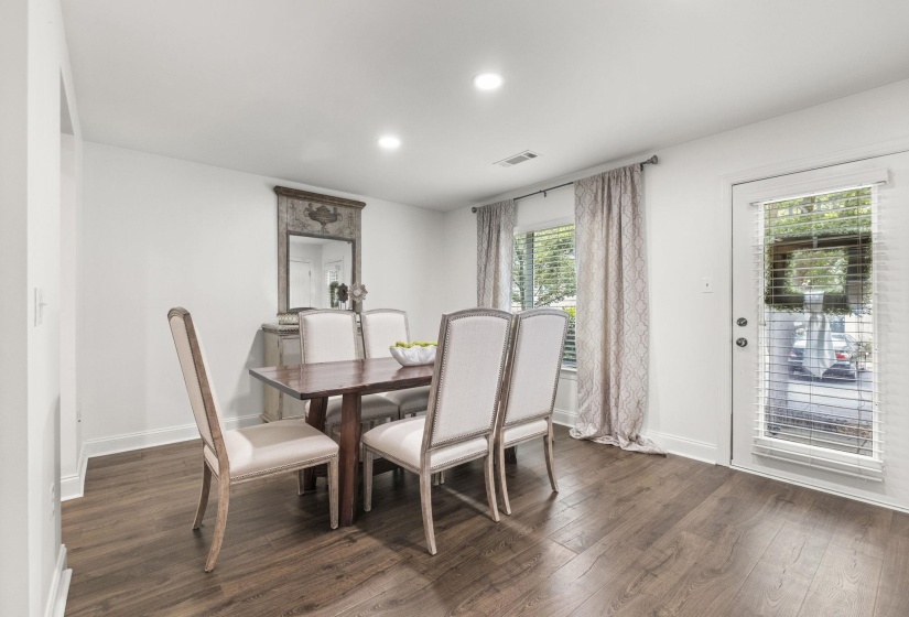 Bright dining area featuring wood-finish flooring, white baseboards, and recessed lighting