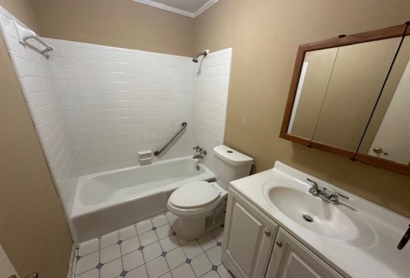 Bathroom featuring a white bathtub, white subway tile surround, and a chrome grab bar