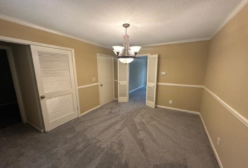 Carpeted interior space featuring a central chandelier