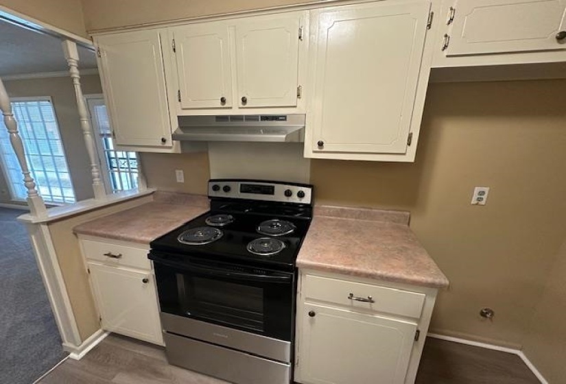 Kitchen featuring white cabinetry, a stainless steel electric range, and laminate countertops