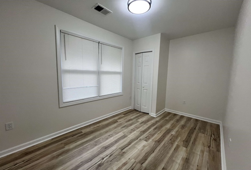Unfurnished bedroom featuring light wood-type flooring and a closet
