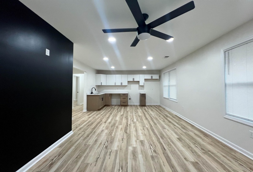 Kitchen with built in desk, light wood finished floors, a ceiling fan, recessed lighting, and light countertops