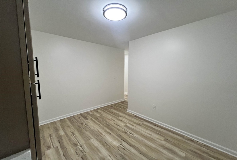 Unfurnished room featuring light wood finished floors and baseboards