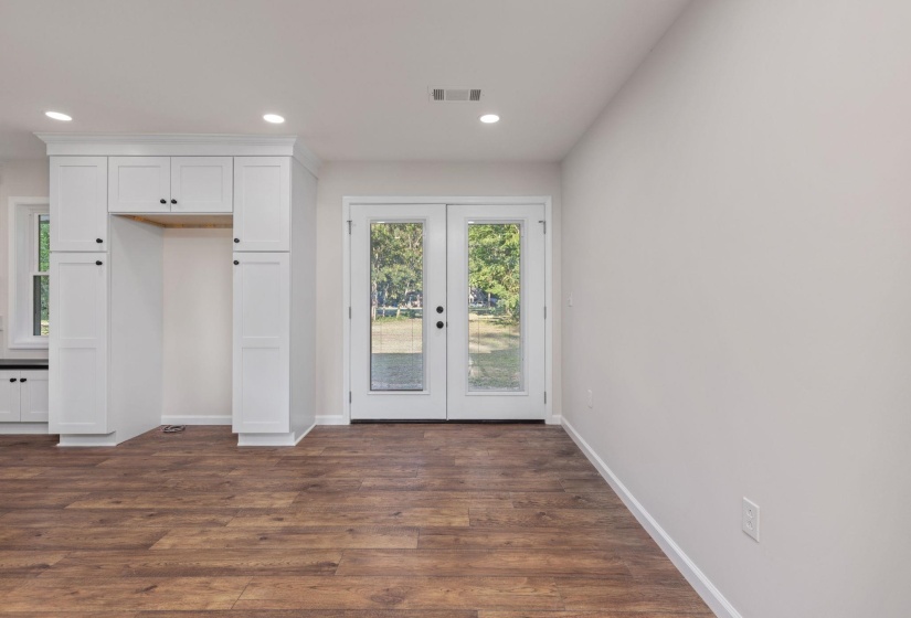 Unfurnished bedroom featuring french doors, access to exterior, recessed lighting, and dark wood finished floors