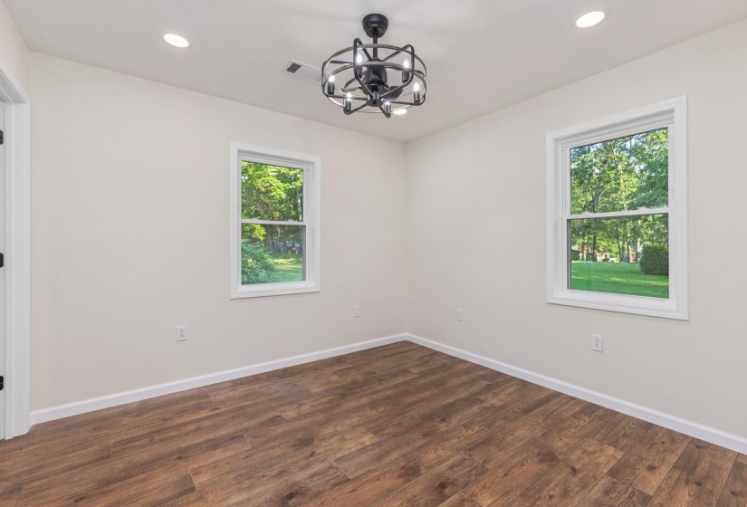 Unfurnished room featuring a chandelier, recessed lighting, and dark wood-type flooring