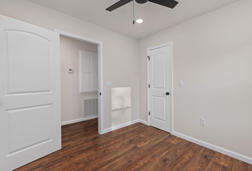 Empty room with a ceiling fan, dark wood-style floors, and recessed lighting