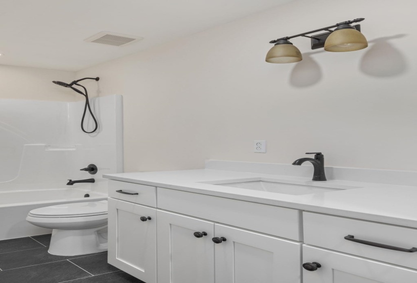 Bathroom with vanity, tile patterned floors, and shower / bath combination