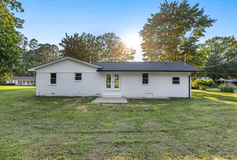 Rear view of house featuring french doors and a yard