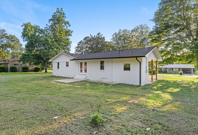 Rear view of house with a yard, a patio, and french doors