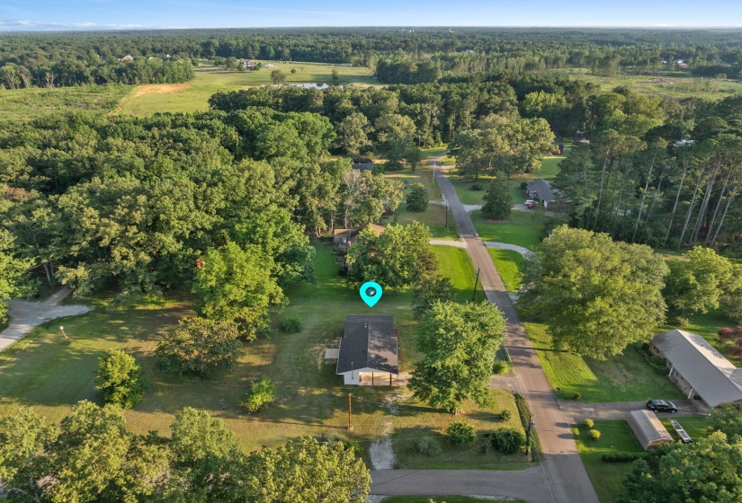 Aerial view of property and surrounding area featuring a forest