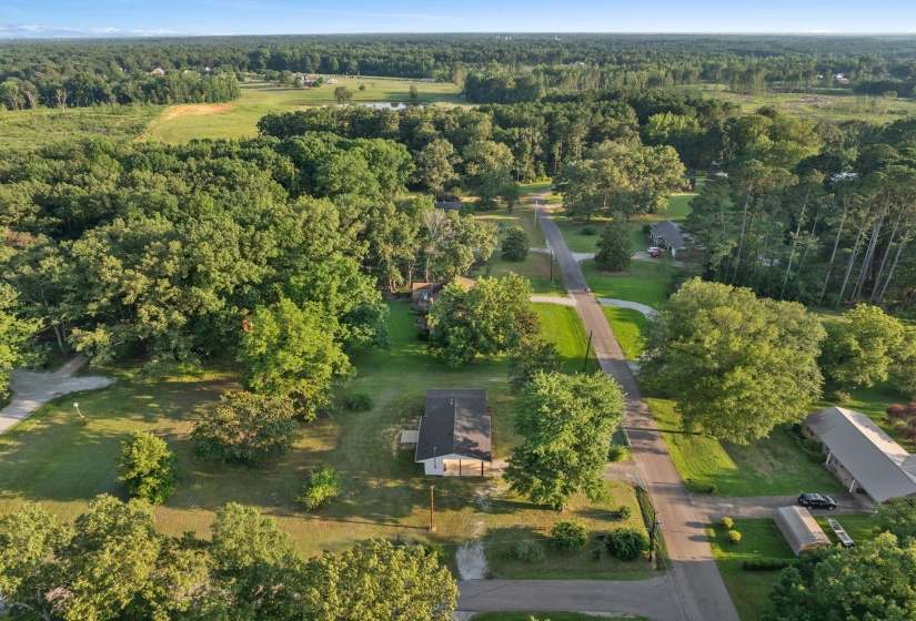 Aerial view of property and surrounding area featuring a forest