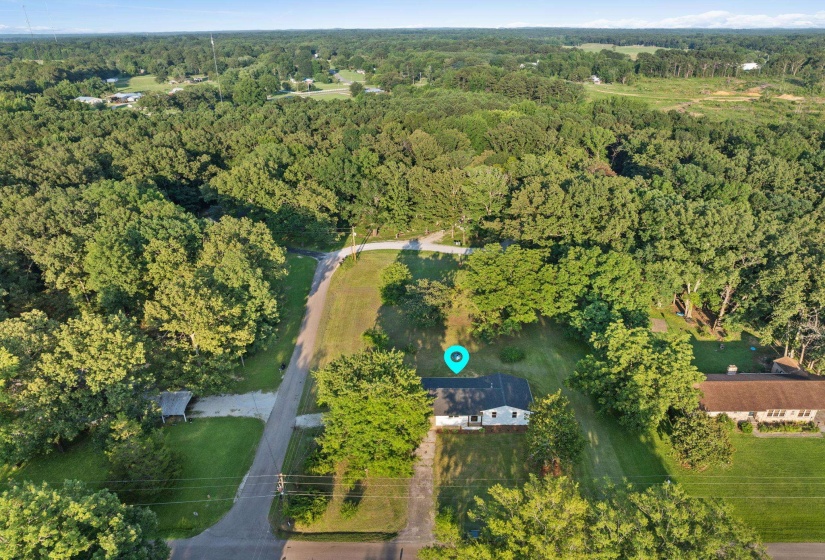 Aerial view of property and surrounding area with a forest