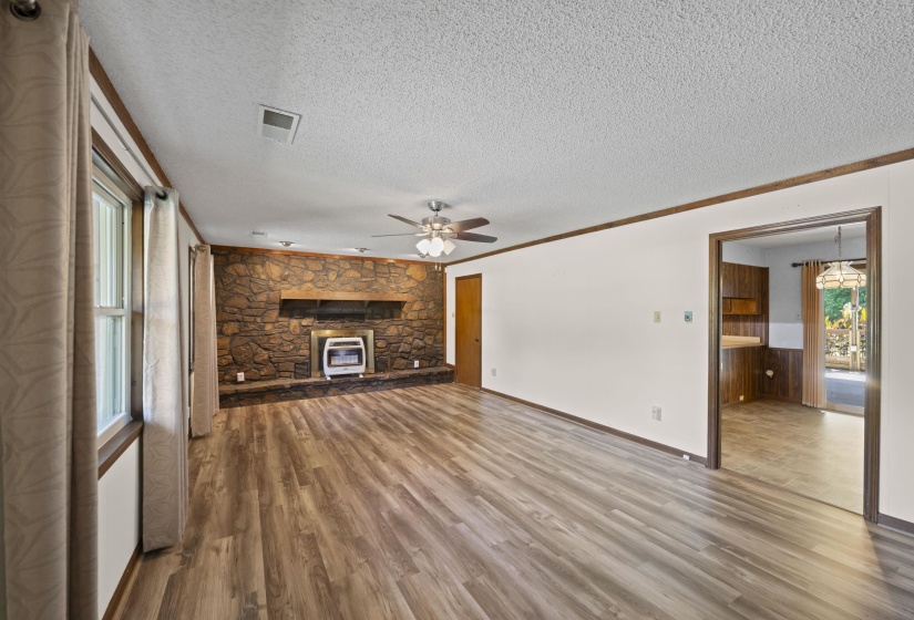 Spacious living area featuring wood-finish flooring and a ceiling fan