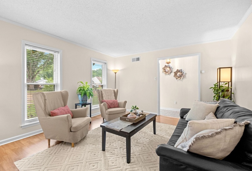 Spacious living area featuring wood-finish flooring, white baseboards, and a neutral wall color