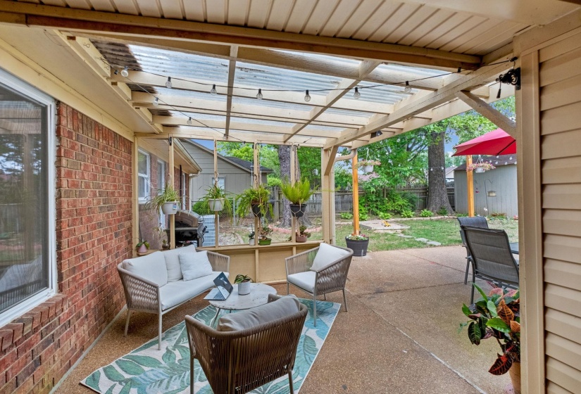 Covered patio with a clear corrugated roof and exposed wood beams