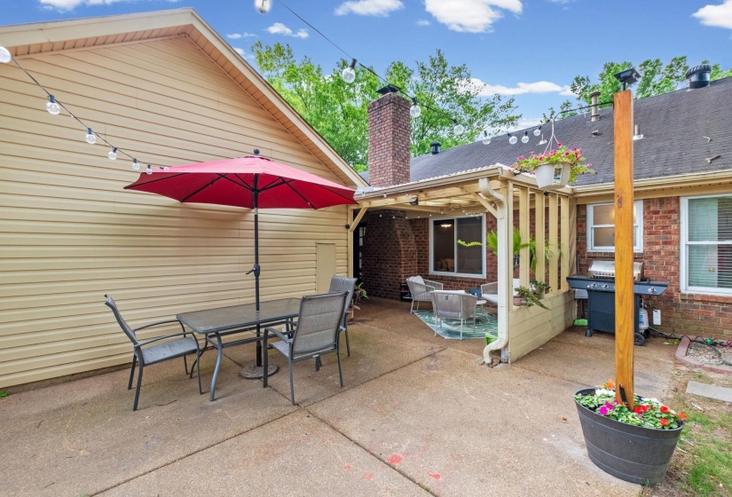 Expansive concrete patio offering multiple defined areas for outdoor enjoyment