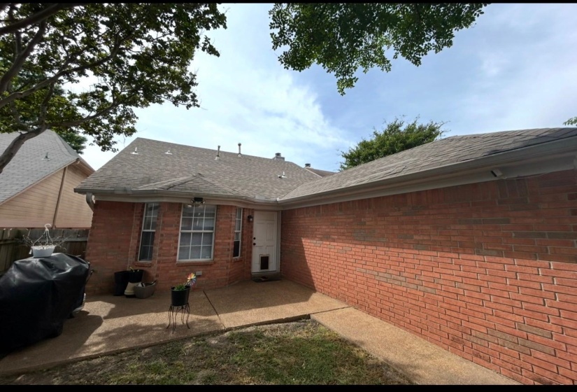 Red brick exterior with a grey shingle roof and white gutters
