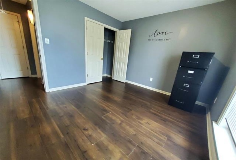 Interior room featuring wood-finish flooring and a light blue wall color