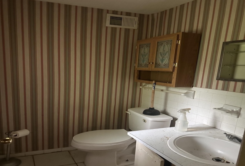 Full bathroom featuring a single white ceramic sink, white countertop, and white tile backsplash