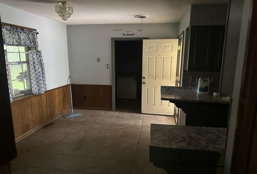 Kitchen area featuring dark cabinetry, speckled countertops, and a tiled backsplash
