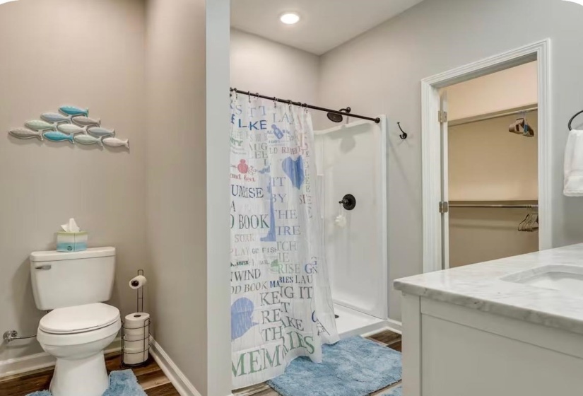Full bathroom featuring a white vanity with a light-colored countertop, an undermount sink, and a framed mirror above