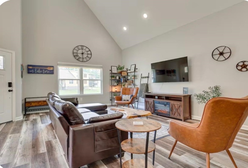 Spacious living area featuring a vaulted ceiling and recessed lighting