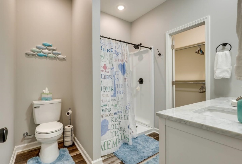 Full bath with vanity, a shower stall, and dark wood-style floors