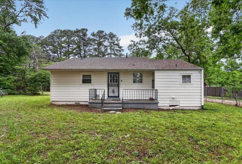 Rear elevation featuring white siding and a covered porch