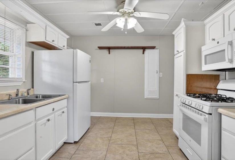 Kitchen featuring white cabinetry, light countertops, and tile flooring
